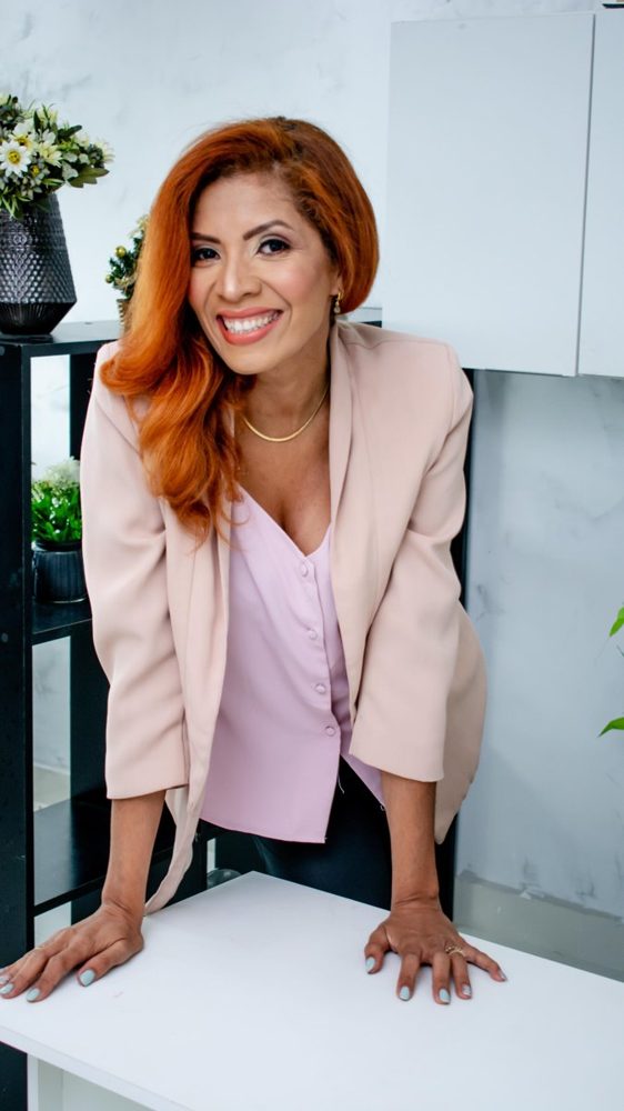 Nayane Crysnay, especialista em camuflagem reparadora, sorrindo em seu espaço de atendimento